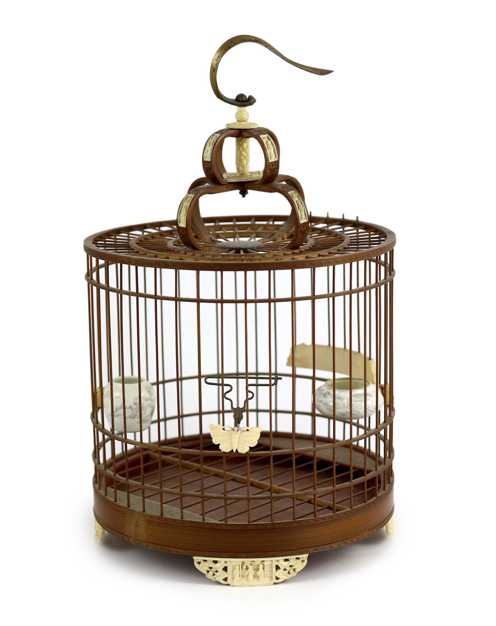 A Chinese bamboo and Guangzhou ivory mounted bird cage, late Qing dynasty, with two Guangxu mark and period porcelain bird feeders (1875-1908), cage 32.5cm high to top of handle